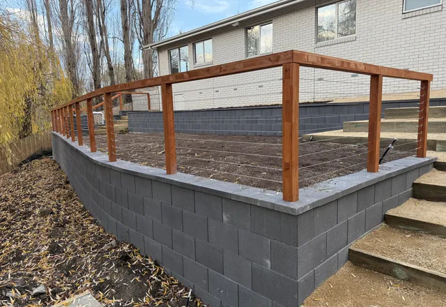 Grey block retaining wall with timber and stainless cable balustrade and steps