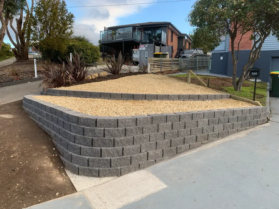 Curved block retaining wall with a compacted gravel terrace behind it