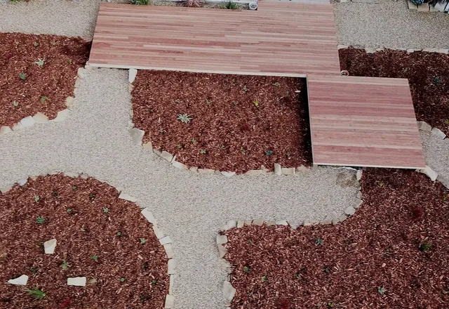 Flowing pattern of contrasting red and white gravel with paver stepping stones