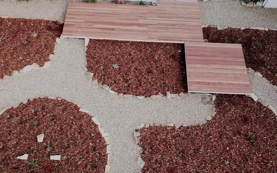 Contrasting red and white decorative gravel laid in a flowing pattern with pavers