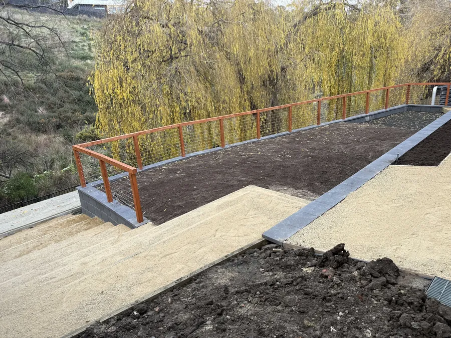 Level gravel terrace and garden bed held by the new retaining wall