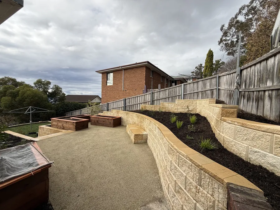After: the gravel terrace with timber raised beds and a built-in sandstone bench