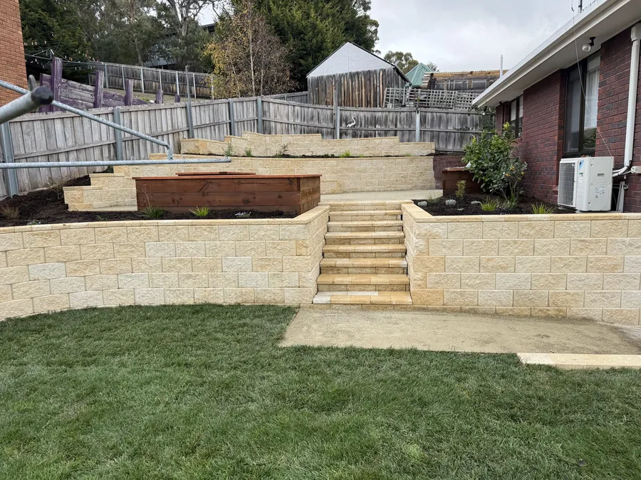 After: sandstone-block terraces and steps rising from the fresh new lawn