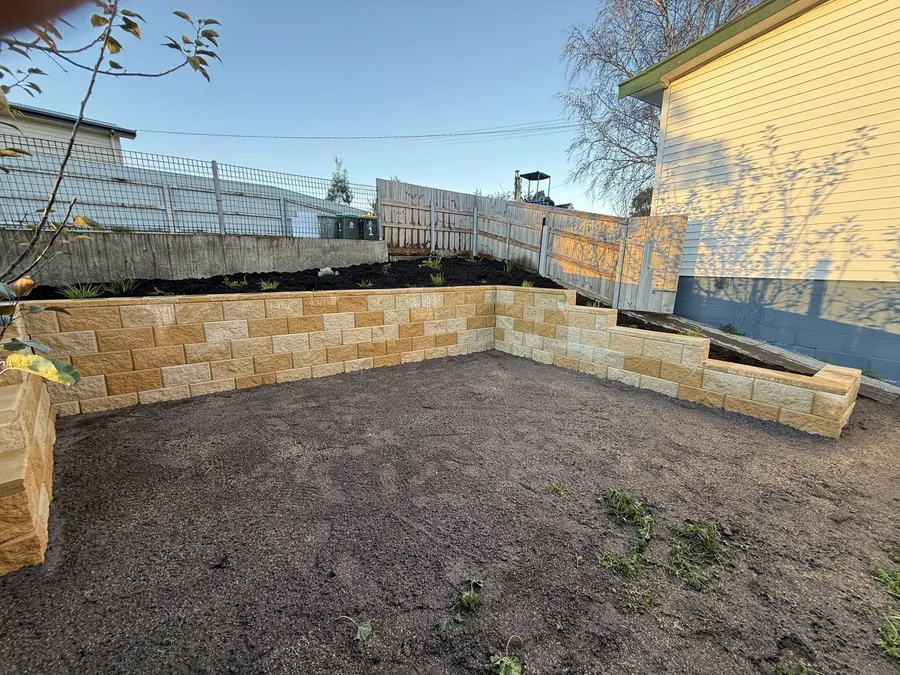 After: the full run of wall holding the freshly planted bank