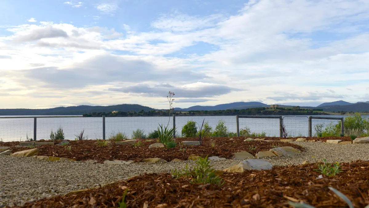 Garden design on a waterfront block, with beds and gravel shaped around the coastal view